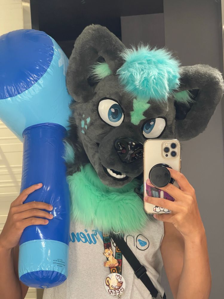 Hyena fursuiter holding his inflatable bonking hammer