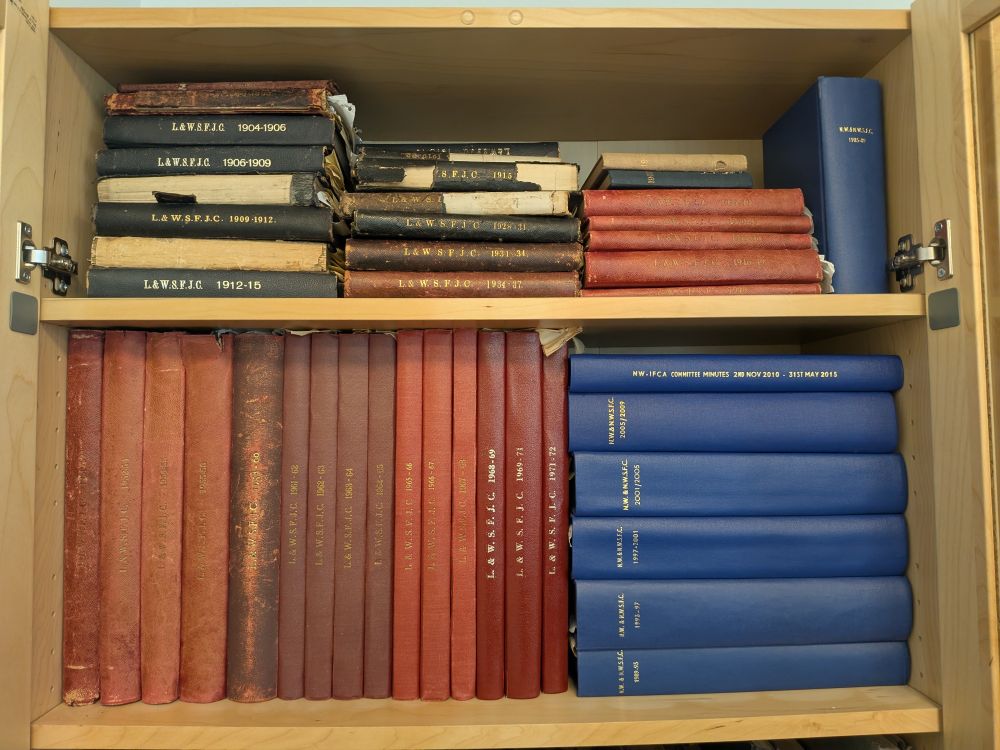 Bookshelf containing Lancashire and Western Sea Fisheries Committee annual reports from early 1900s. 