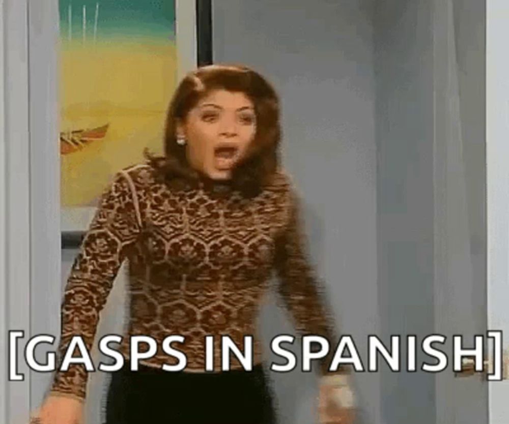 a woman is standing in a doorway with her mouth open and gasps in spanish written on her face .