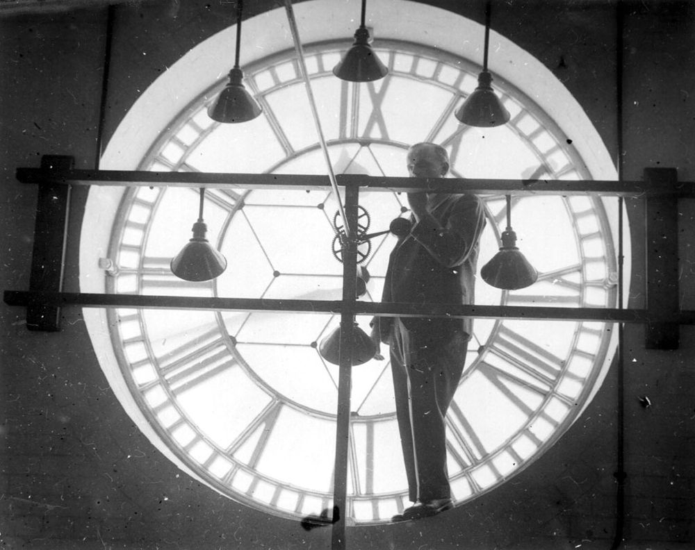 An Engineer inspecting the Town Hall clock immediately after installation