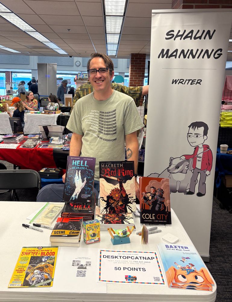 Shaun standing at his table at Ann Arbor Comic Arts Festival