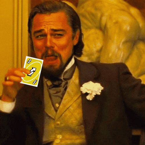 a man in a suit holds up a card that says ' u ' on it