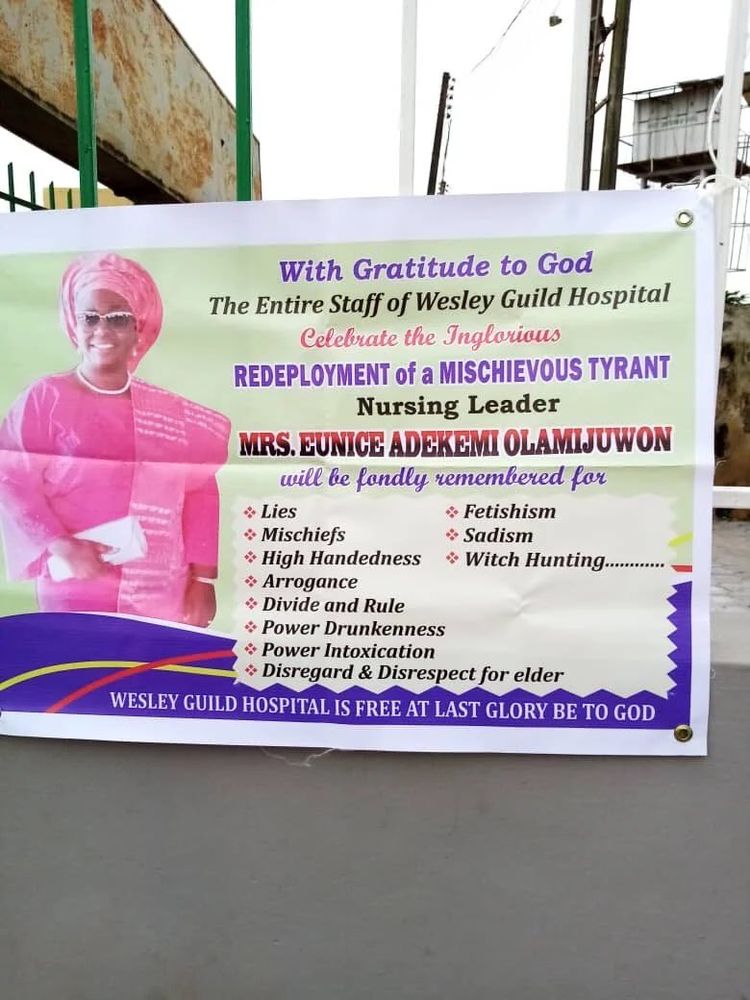 A hung banner featuring a middle-aged Nigerian woman in pink clothing and glasses, with text that reads: With gratitude to God, the entire staff of Wesley Guild Hospital celebrates the inglorious redeployment of a mischievous tyrant, nursing leader Mrs Eunice Adekemi Olamijuwon, who will be fondly remembered for (list of transgressions, including lies, etc).