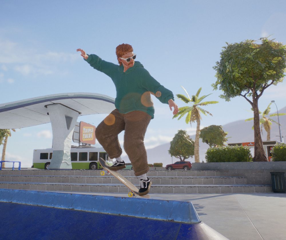 a ginger chubby person in khakis and a teal hoodie grinding a rail in an outdoor skatepark