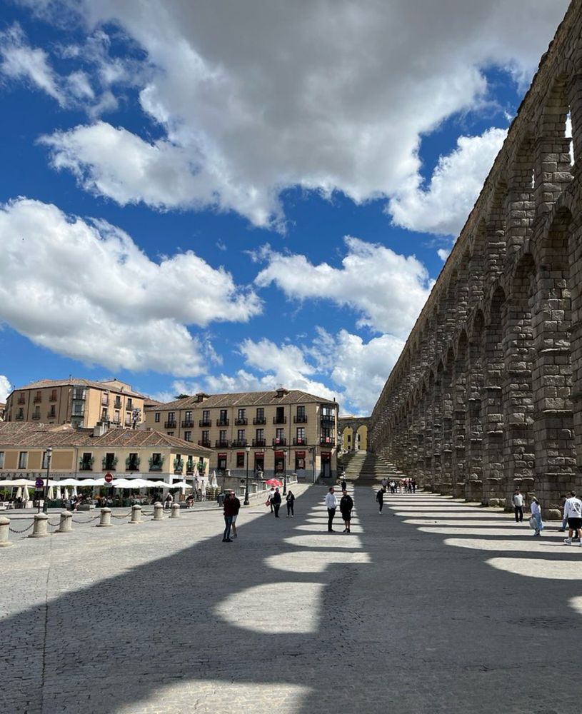 The aqueduct in Segovia, Spain on the right with its shadow on the ground