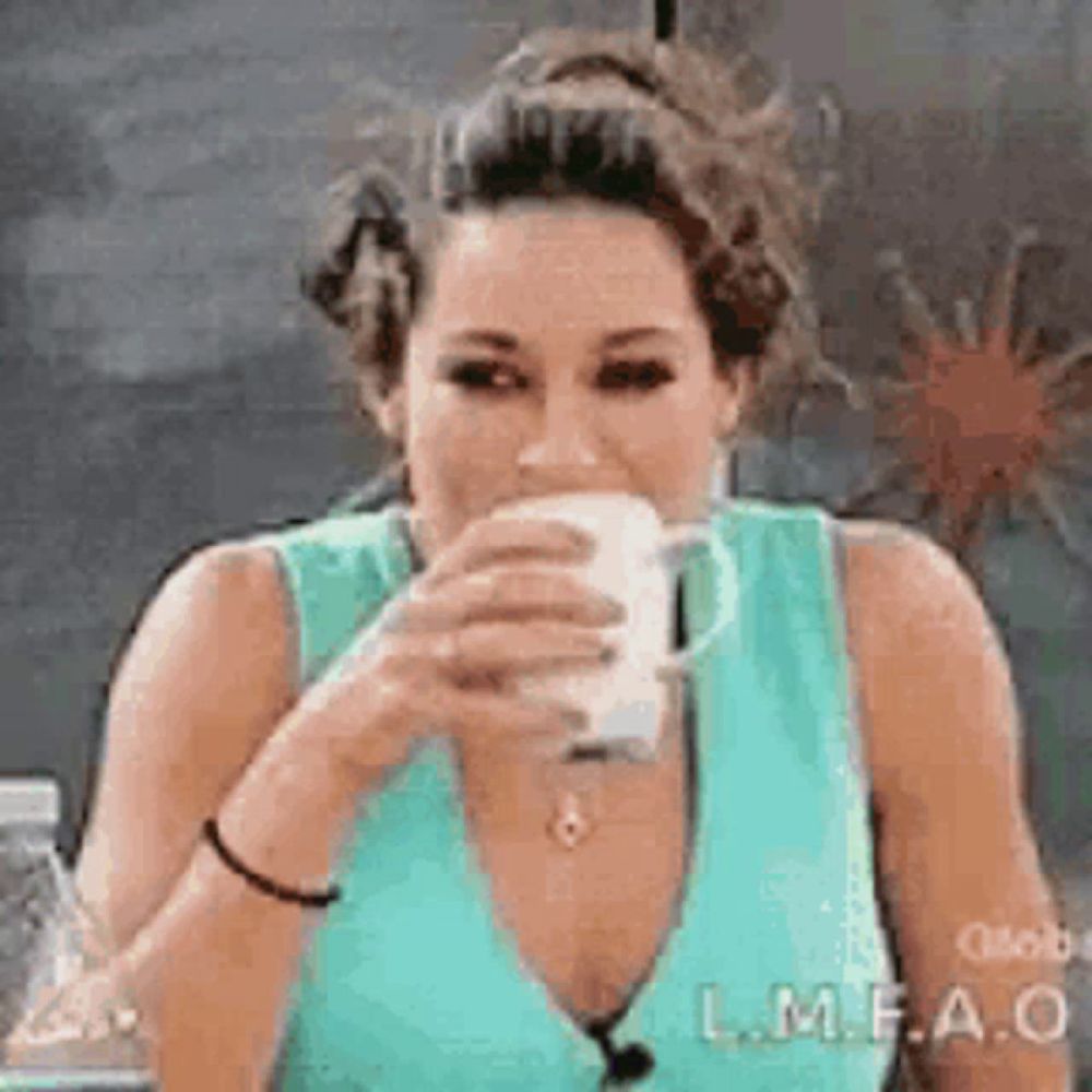 a woman is drinking a cup of coffee while wearing a blue tank top .