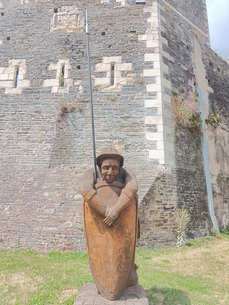 A wooden sculpture of a castle guard who looks really bored. 