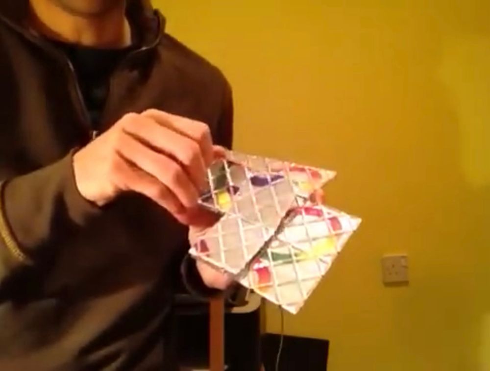 Nahaufnahme wie eine Person das Geduldspiel Rubik‘s Master Magic in den Händen hält. Gelblicher Screenshot aus einem alten Video