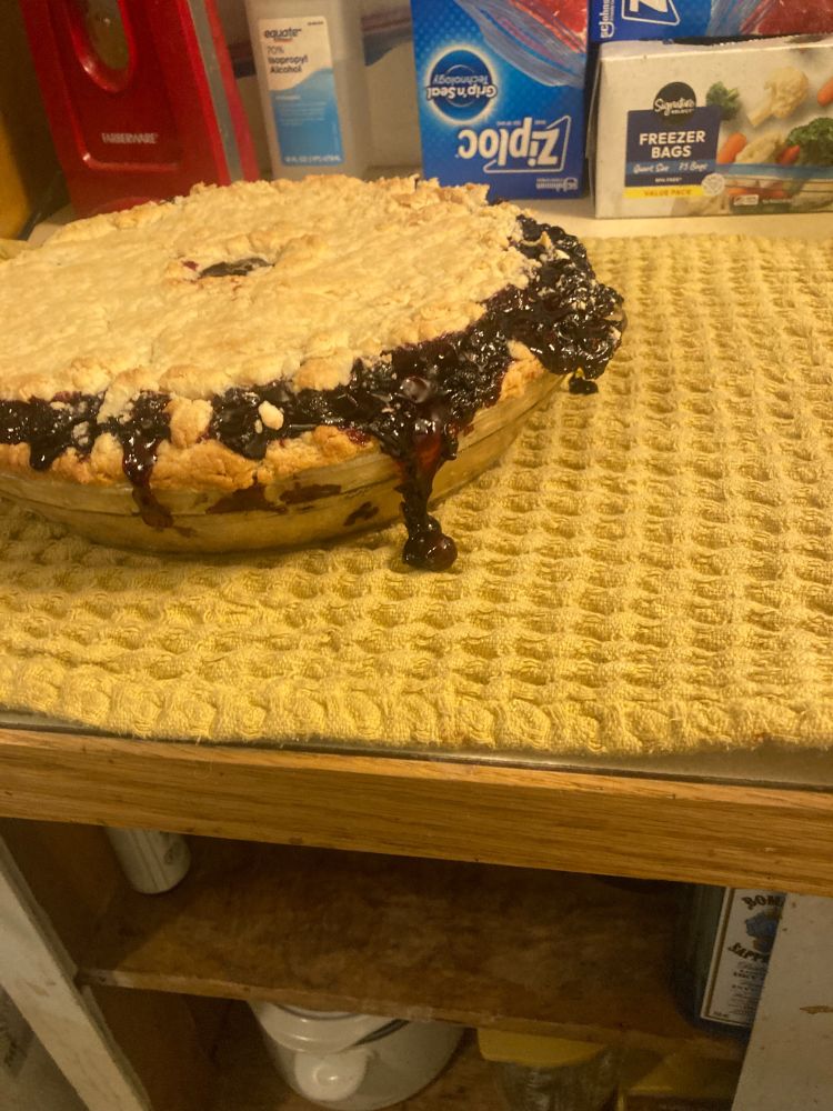 Close-up of the pie filling oozing out over the side just a little bit.