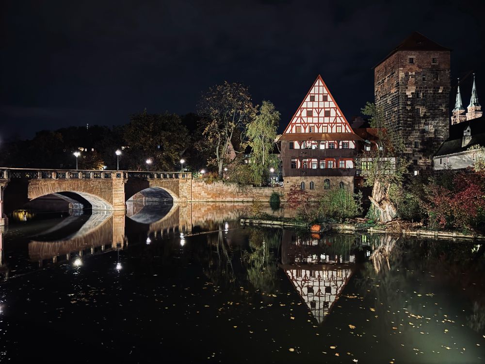 A bridge and a old house reflected in the Pegnitz in Nürnberg at Night