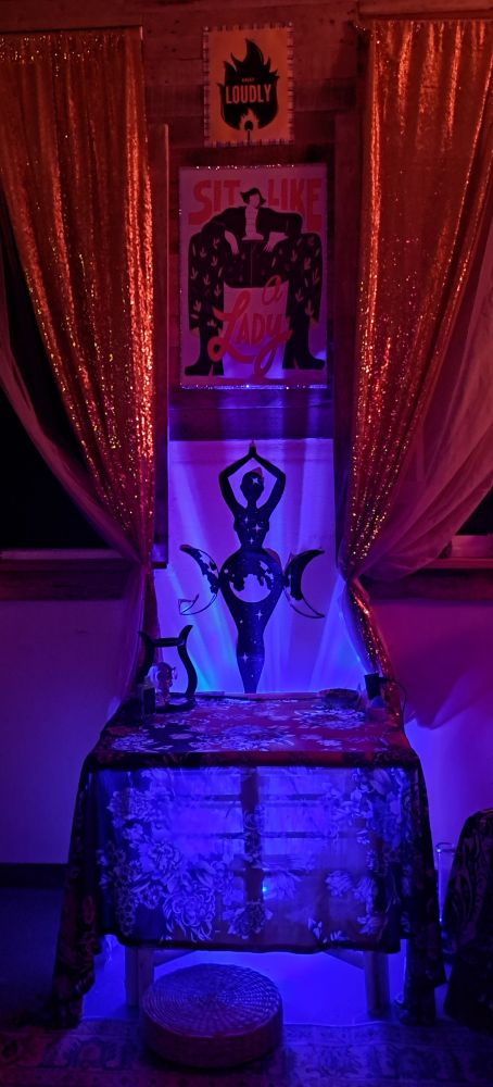 A table underline with blue light highlighting a world goddess vinyl sticker on the wall