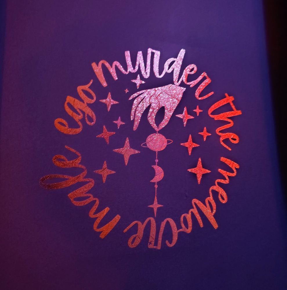 Murder the mediocre male ego vinyl cut out in a circle on wall with womans hand dangling worlds