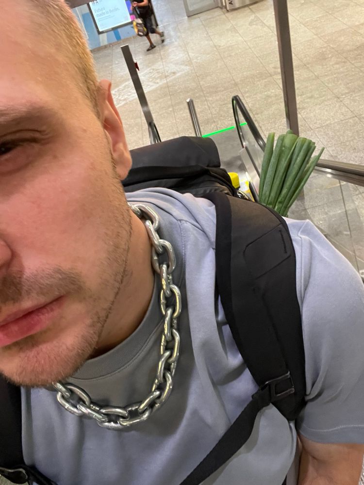 Ein Selfie am Kopf vorbei, ein Bund Lauchzwiebeln guckt aus dem Rucksack