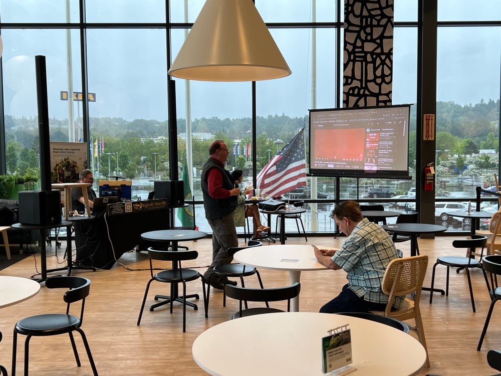 A guy singing a song while looking at lyrics, standing in an IKEA restaurant.