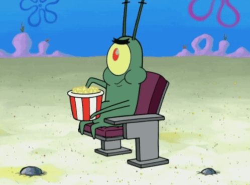 plankton from spongebob is sitting in a chair holding a bucket of popcorn