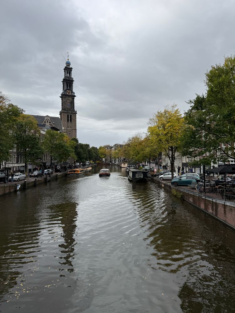 Westerkerk in Amsterdam. Tall slim tower overlooking a busy canal