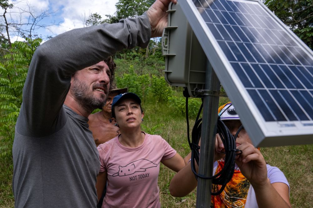 A member of the FieldKit team demonstrates how to work with an weather station in a field in Leticia, Colombia. 