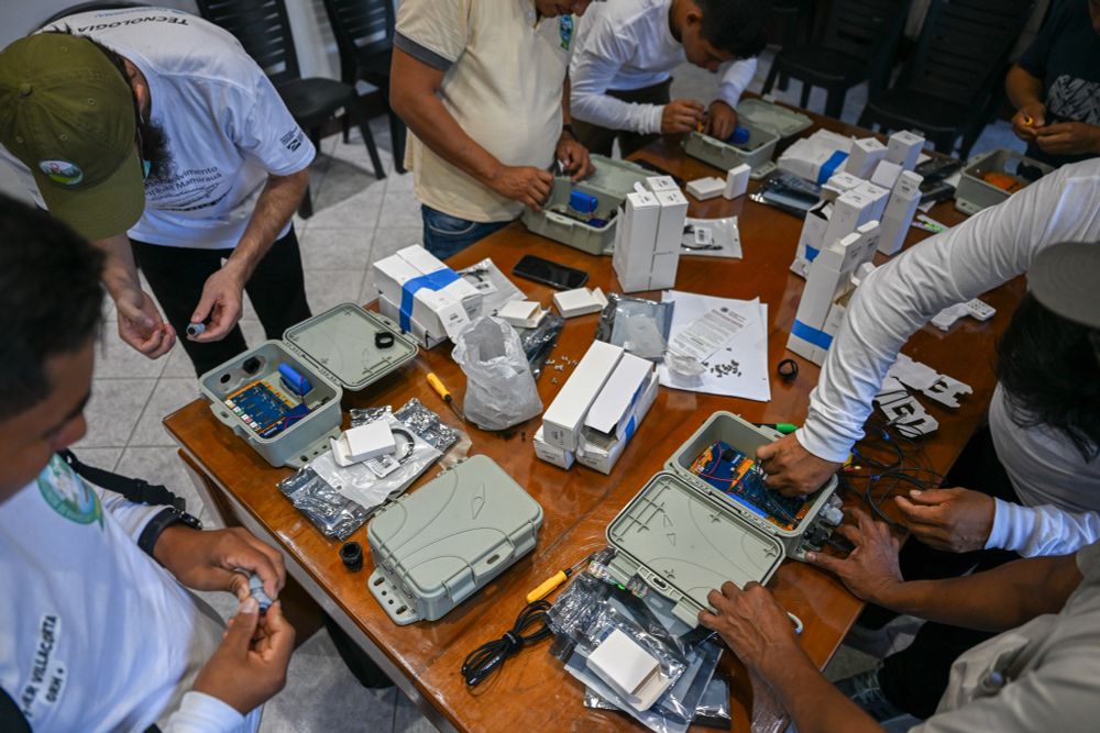 Members from the community and nonprofits work on assembly of FieldKit sensors on a table during a FieldSchool workshop. 
