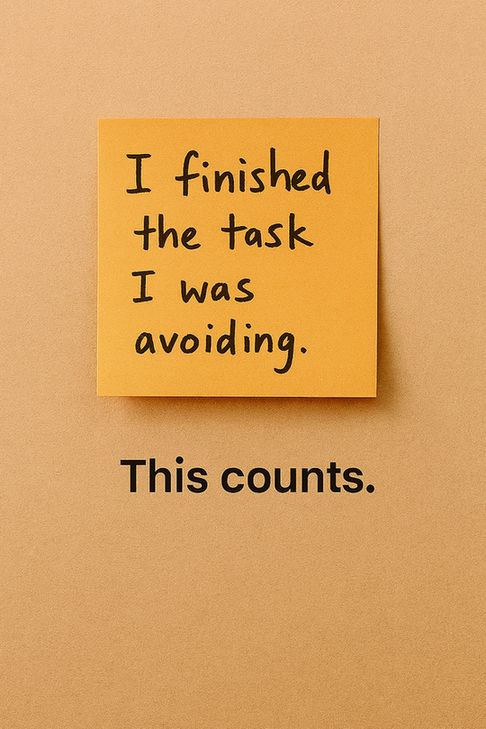 A warm orange sticky note on a textured beige wall reads “I finished the task I was avoiding” in casual black handwriting. Below it, the phrase “This counts.” is centered in bold black text. The lighting is soft and even, evoking a sense of quiet persistence and emotional relief.
