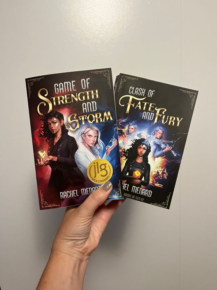 Two books on white. Game of Strength and Storm and Clash of Fate and Fury 