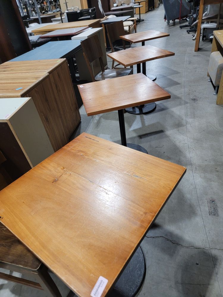 four wooden cafe tables in a row