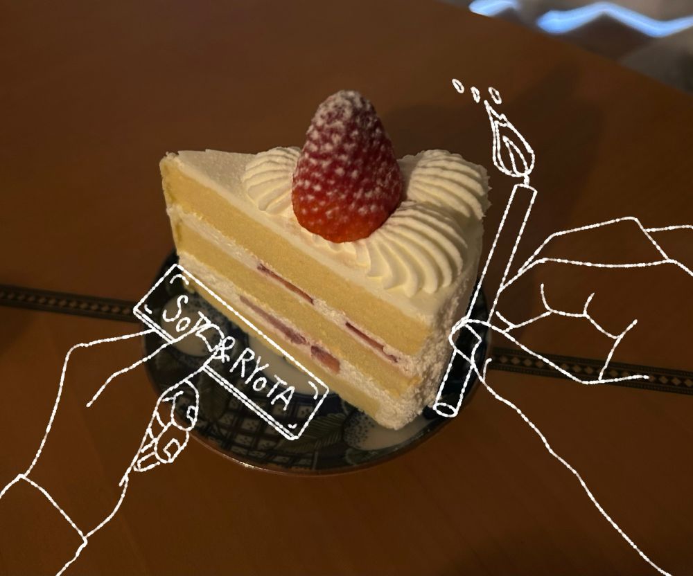 今日私が買ってきたショートケーキの写真に
白い線で左から火のついたロウソクを持つ手と右から名前の書かれたネームプレートを持つ、リストバンドをした手を描き加えたもの