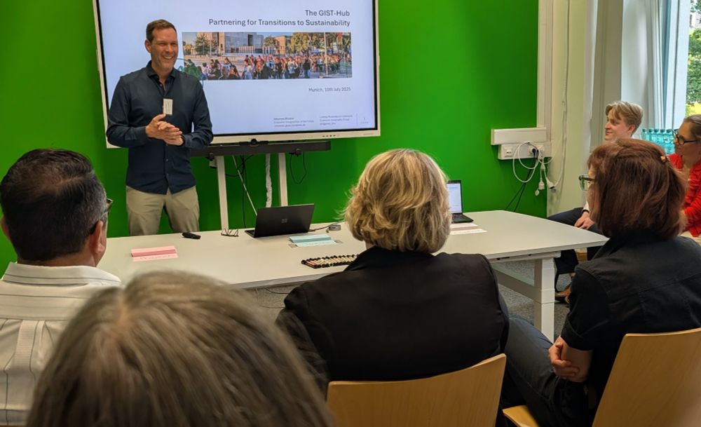 Prof. Johannes Glückler is standing in front of the participants and introduces them to the GIST-Hub project.