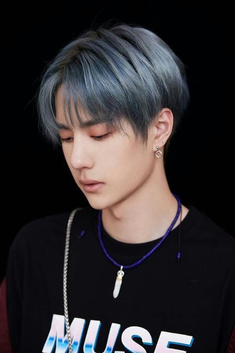 The blue haired photo from produce 202 with the black muse shirt and blue feather necklace and earrings that caused people online to think he was ai generated 