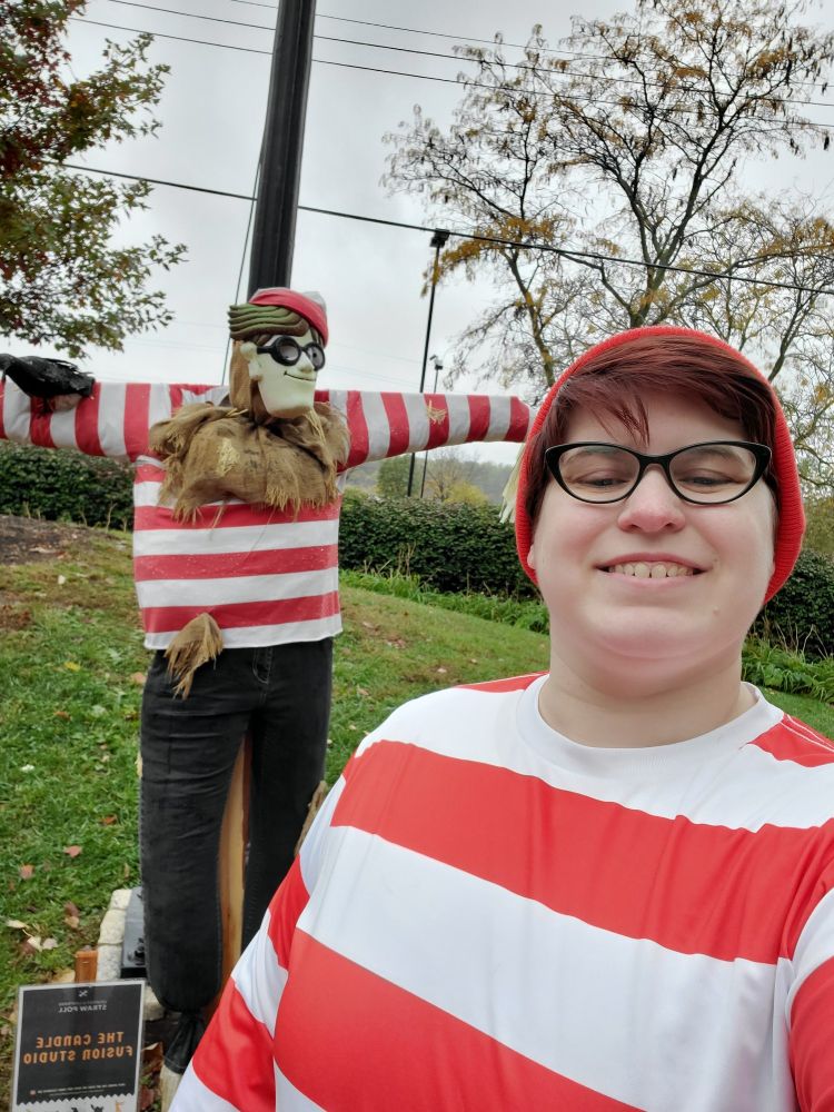 A nerd dressed up as Where's Waldo in front of a scarecrow dressed up as Where's Waldo