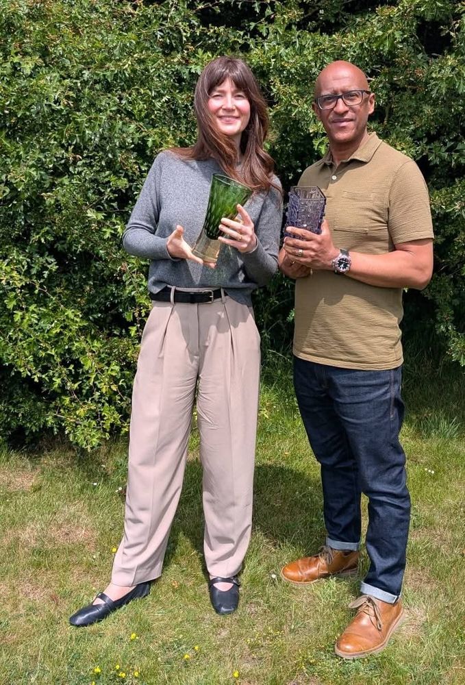 TV host Natasha Raskin Sharp and Bargain Hunt expert David Fergus are both holding a piece of vintage studio glass vases 
