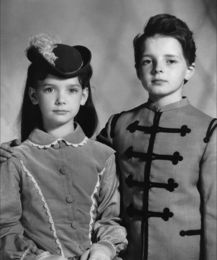 A still from The Innocents, a 1961 horror film based on Henry James' The Turn of the Screw, depicting two scary looking children, a girl aged around 8 (left) and a boy aged around 11 (right) in Victorian clothes