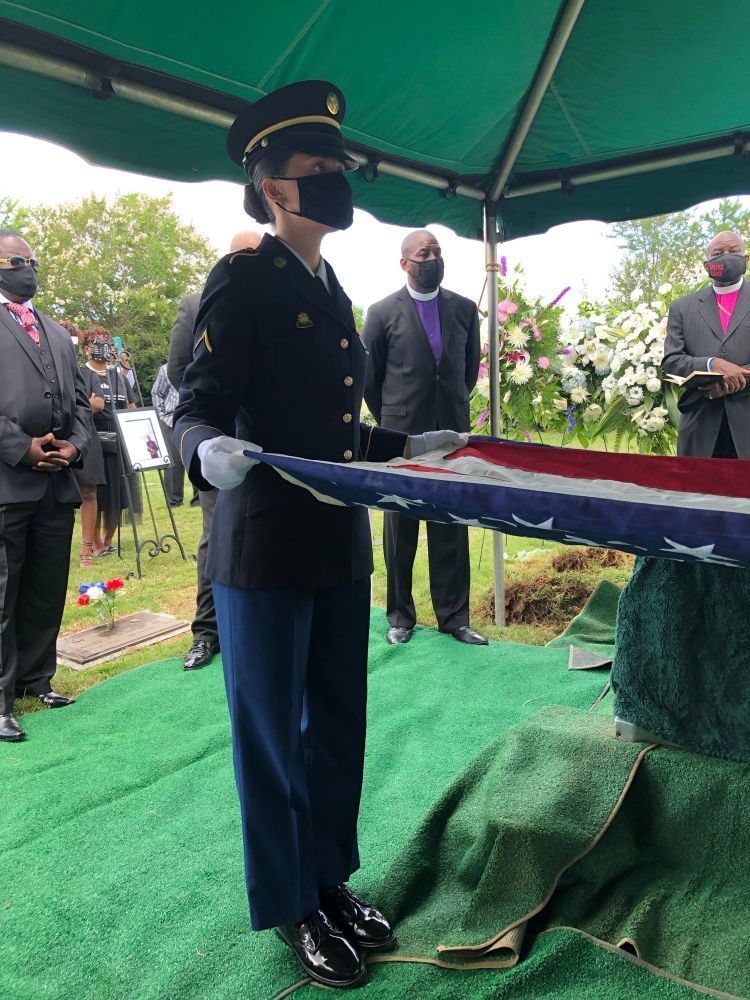 Female soldier folding American flag 