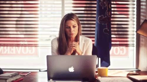 a woman is sitting at a desk with a laptop computer .