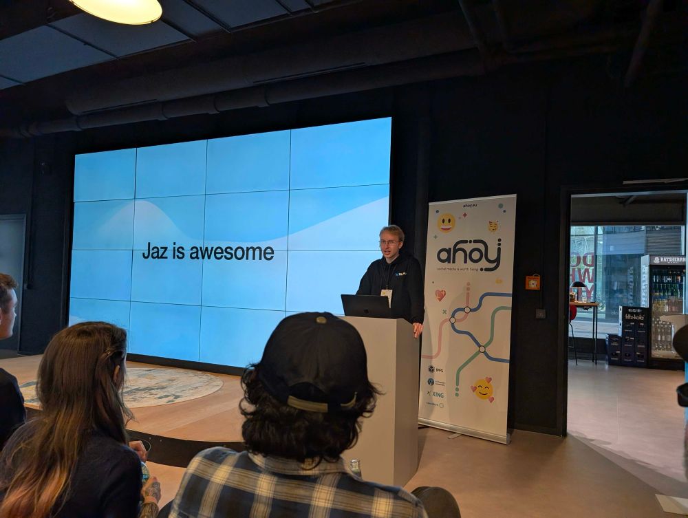 Me in front of a big screen that says “Jaz is awesome”