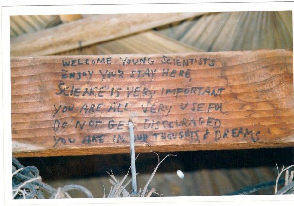 the armrest of a chair. Written on it in dark ink: "Welcome young scientists. Enjoy your stay here. Science if very important. You are all very useful. Do not get discouraged. You are in our thoughts & dreams."