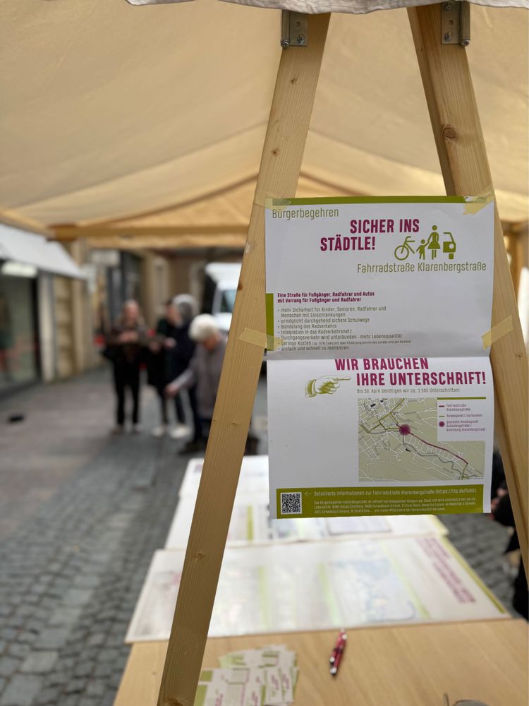 Ein Plakat hängt an einem Stand