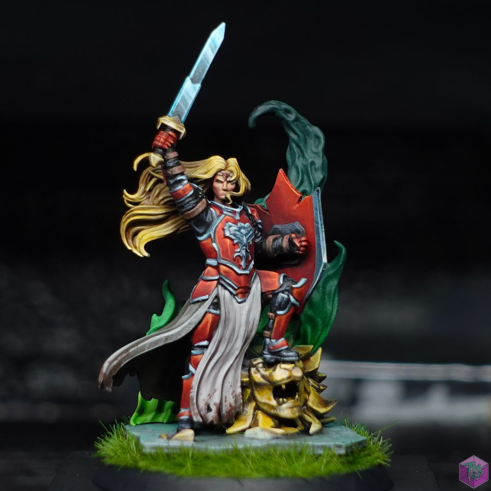 Ser Trys, a blonde haired knight in red armour with a shining metallic trim. 
