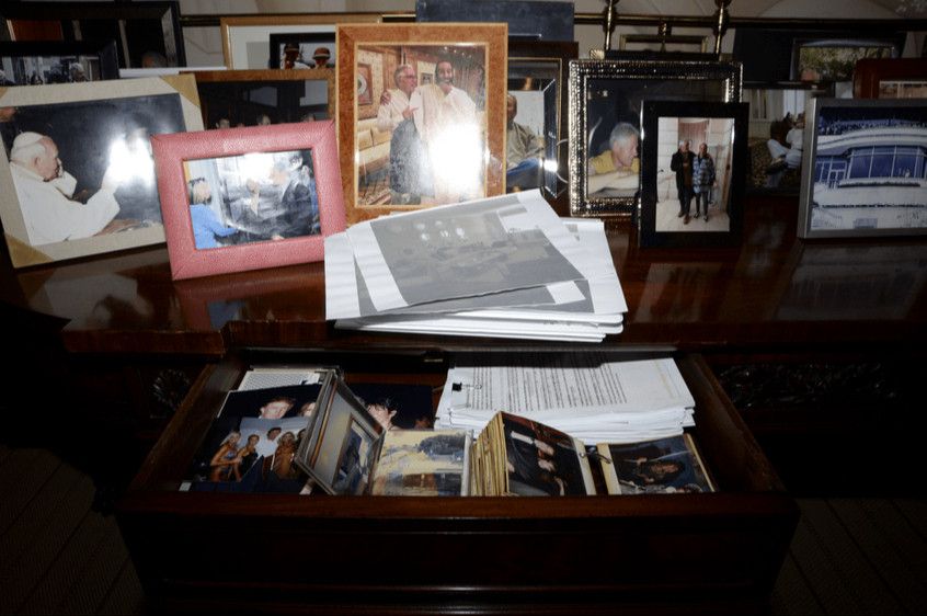 This image is a photograph of a desk drawer crammed with papers and photos that was part of the documents released by the Department of Justice (DOJ) related to the Jeffrey Epstein investigation. 
