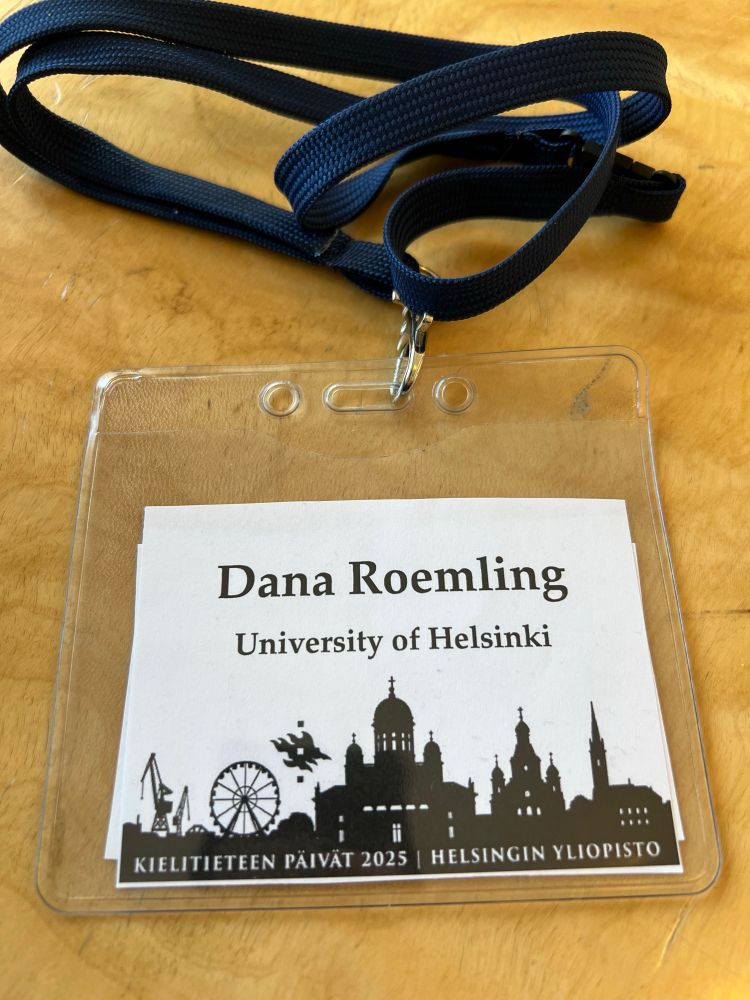 [Black/White conference badge showing the skyline of Helsinki and the post author’s name and temporary affiliation (Dana Roemling, University of Helsinki)]