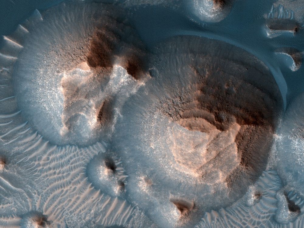 Image shows two large mounds with layers that give them a stair-stepped appearance. (NASA/JPL-Caltech/University of Arizona)