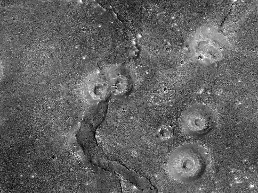 Image shows a series of small mounds with depressions at their tops located next to ridged formations. Some of the ridges are thin but others are very thick and large. (NASA/JPL-Caltech/University of Arizona)