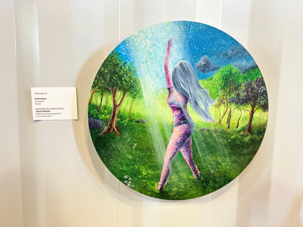“Sun Grove”, an acrylic on canvas painting featuring a woman reaching toward the sunlight and pulling off a mourning veil in a sunlit Grove of trees. Lily of the Valley flowers dot the grass. The artist’s signature is scrawled in white on the bottom left (Ariel Ayres ‘25) 

To the left of the painting is the title card, crediting the artist (Ariel Ayres) and the writer behind the short story that inspired the painting (Jamie Batiste).
