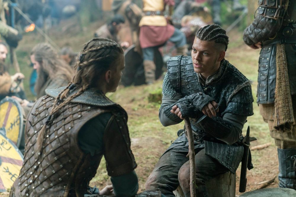 Hvitserk and Ivar sit on log stumps before the battle