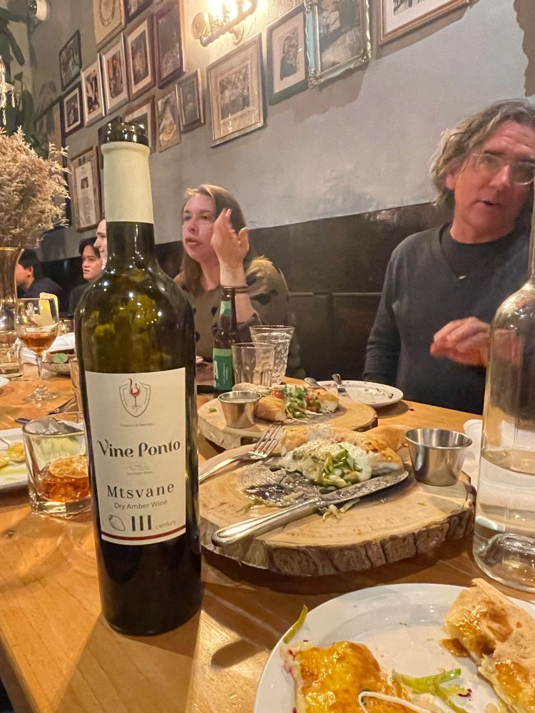 Picture of a table at a restaurant with a bottle of wine labeled ‘mtsvane’