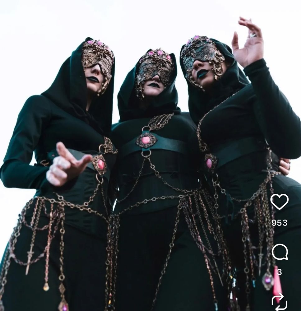 Sleep Token Espera background singers wearing gorgeous golden masks, black hooded clothing and decorated chain harnesses