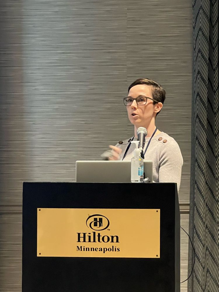 Dr. Simpfenderfer speaking at the podium, explaining her research 