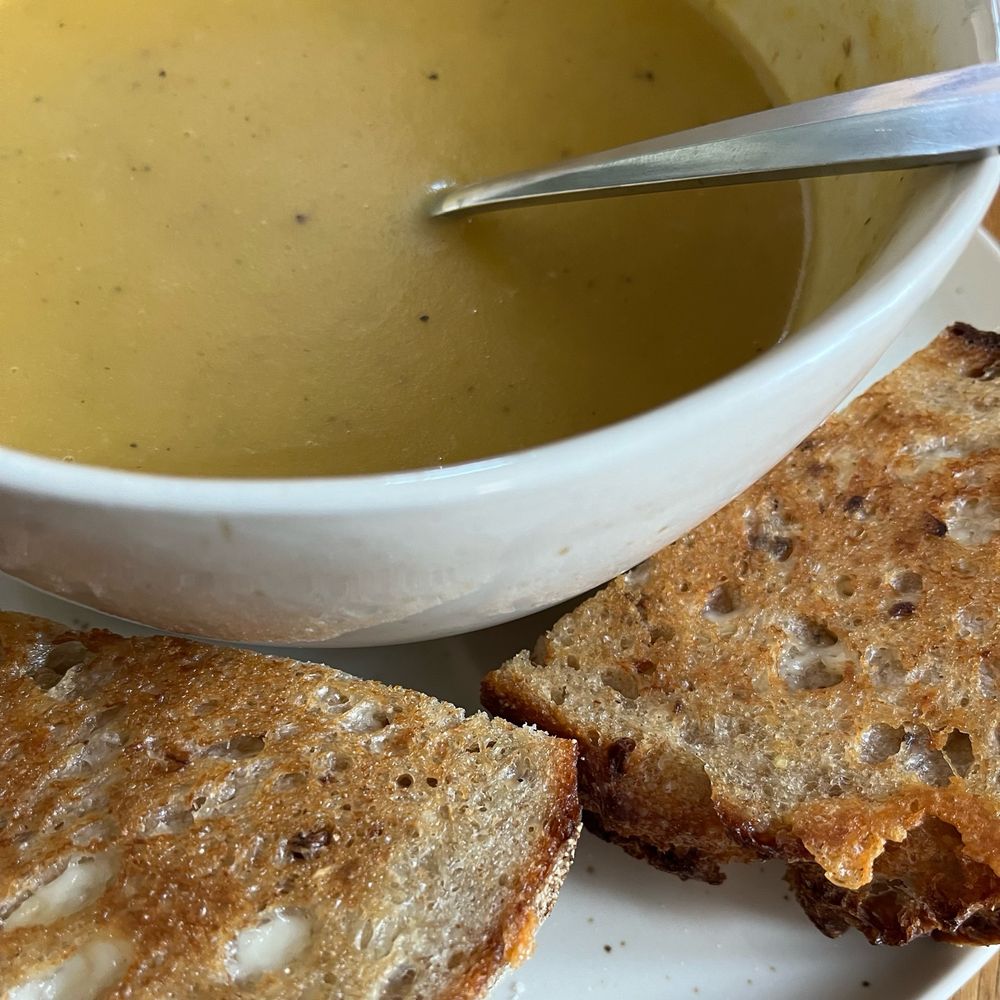 Photo of some squash and coconut soup with a grilled cheese sandwich.