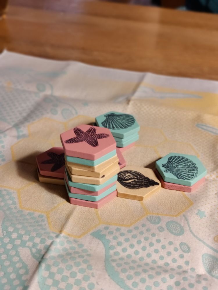 A stack of hexagonal seaside tokens in High Tide 
