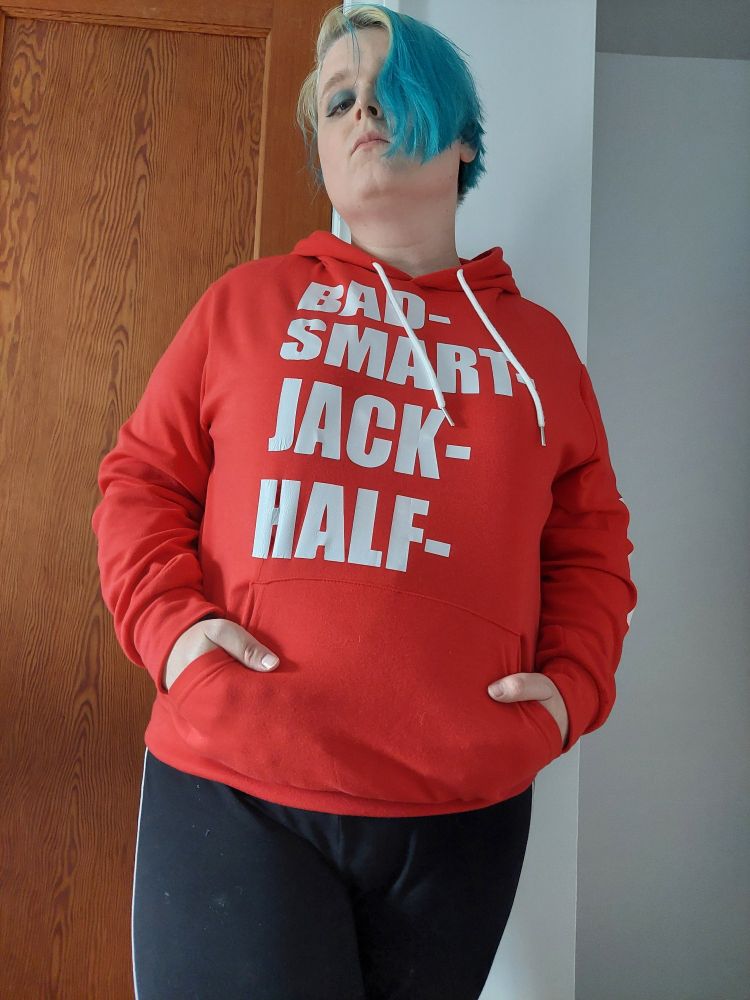 Paula standing in her room, wearing a red hoodie with the script "Bad-, Smart-, Jack-, Half-" in white Impact font.