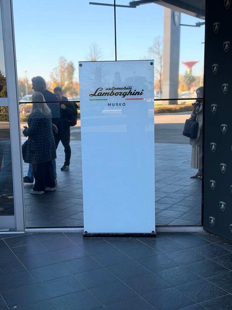 A plain white signboard reading Automobili Lamborghini Museo